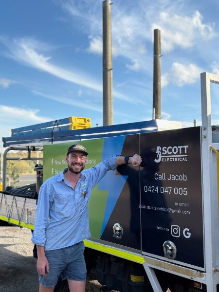 Jacob Scott, licensed electrician and owner of J Scott Electrical, beside his work truck
